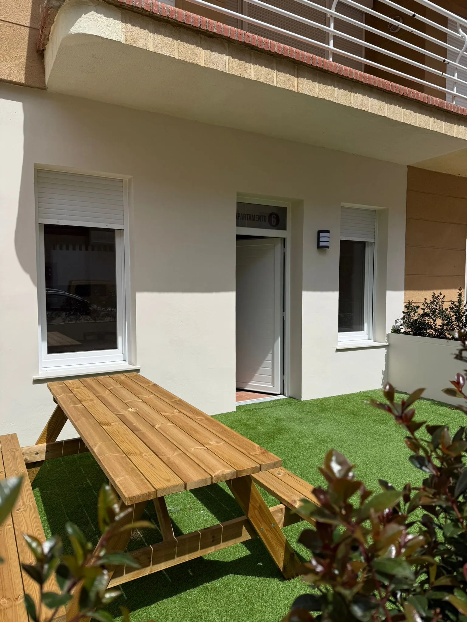 Private Terrasse mit Rasen und Picknicktisch aus Holz